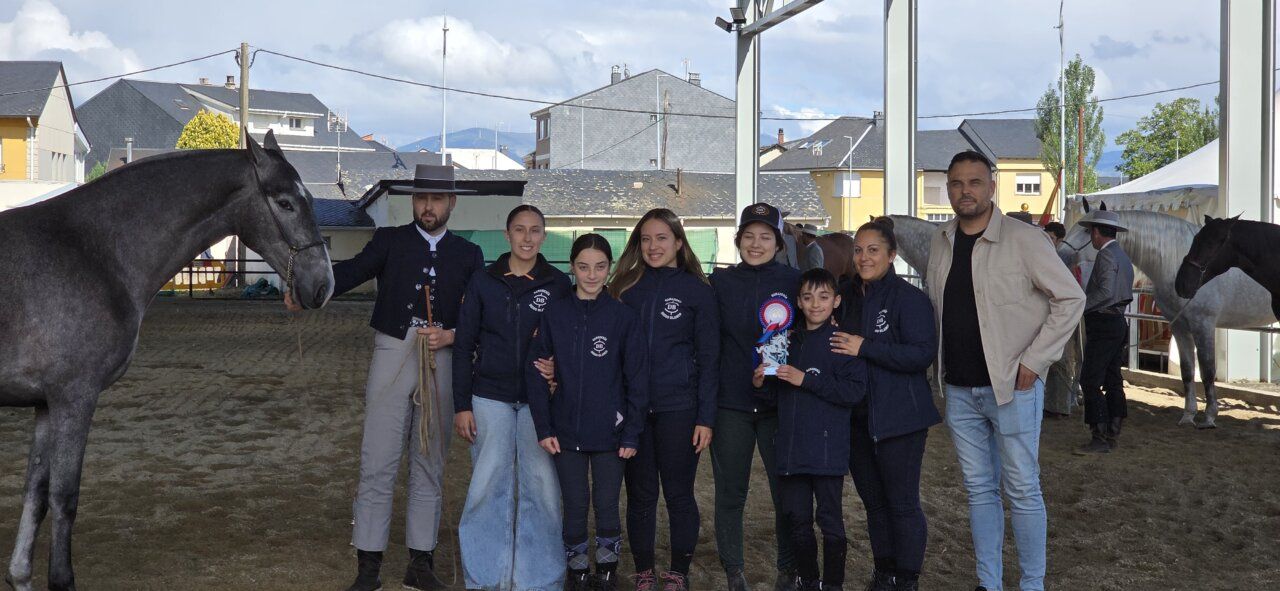 Grupo de personas posando con caballos en un evento ecuestre