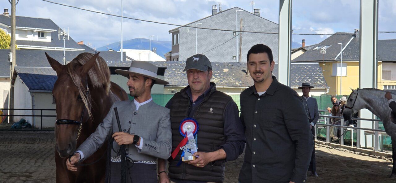 Tres hombres sosteniendo un trofeo en un evento ecuestre
