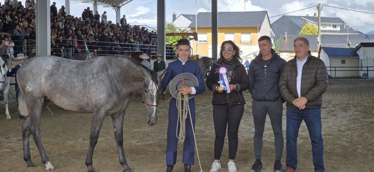 Joven con caballo en evento ecuestre con público al fondo