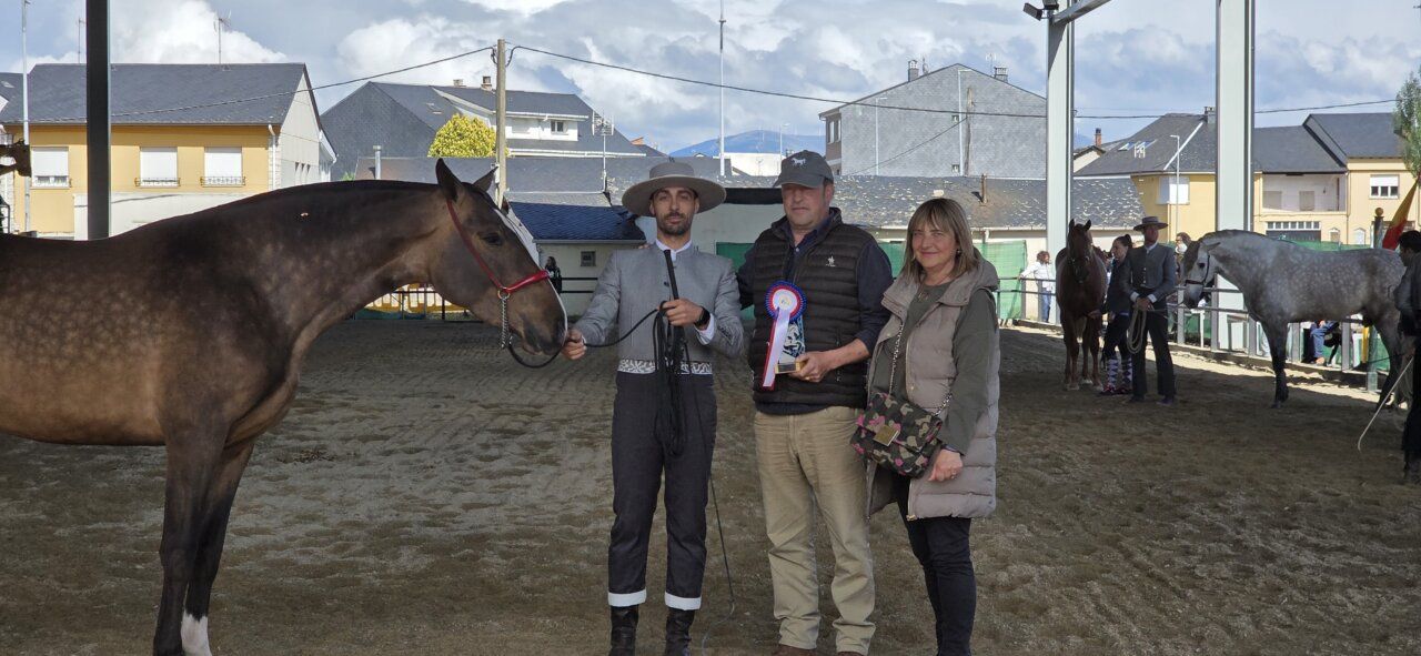 Tres personas posando con un caballo en un evento ecuestre