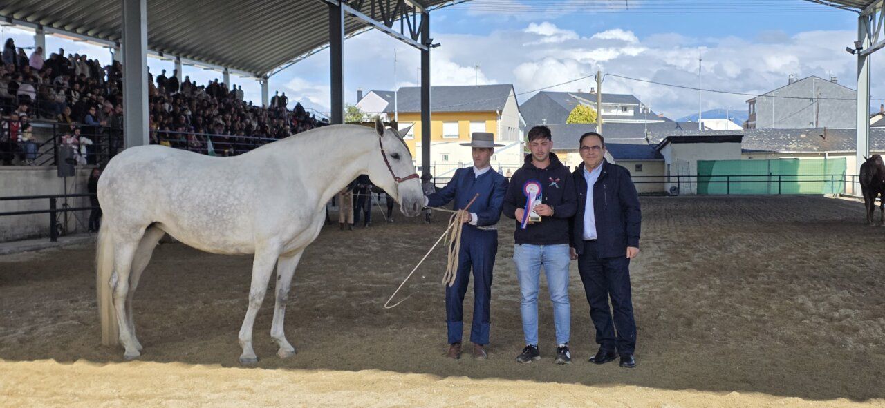 Tres personas junto a un caballo en un evento ecuestre