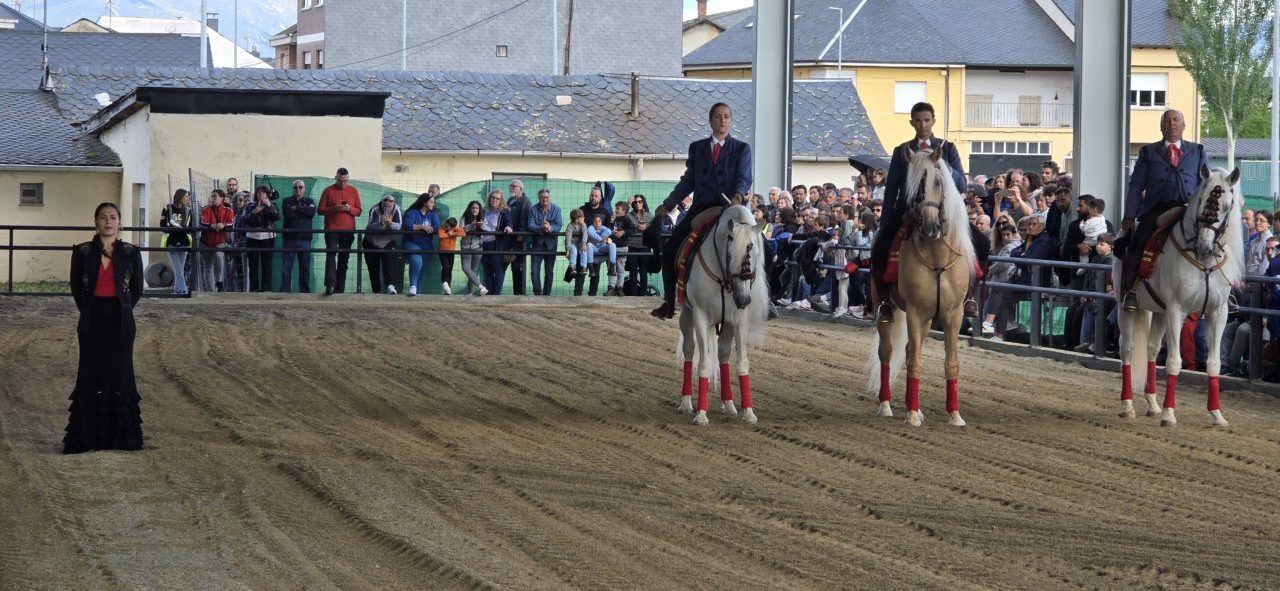Acto de premiación con jinetes a caballo y una mujer en el centro