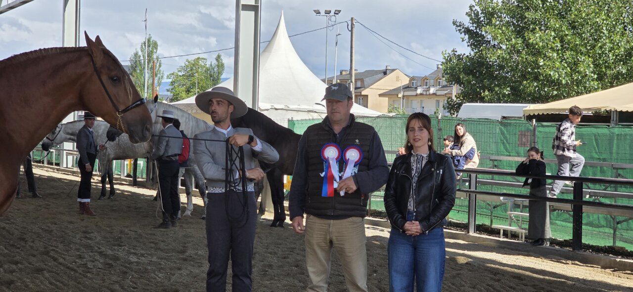 Participantes en un concurso ecuestre con un caballo y premios.