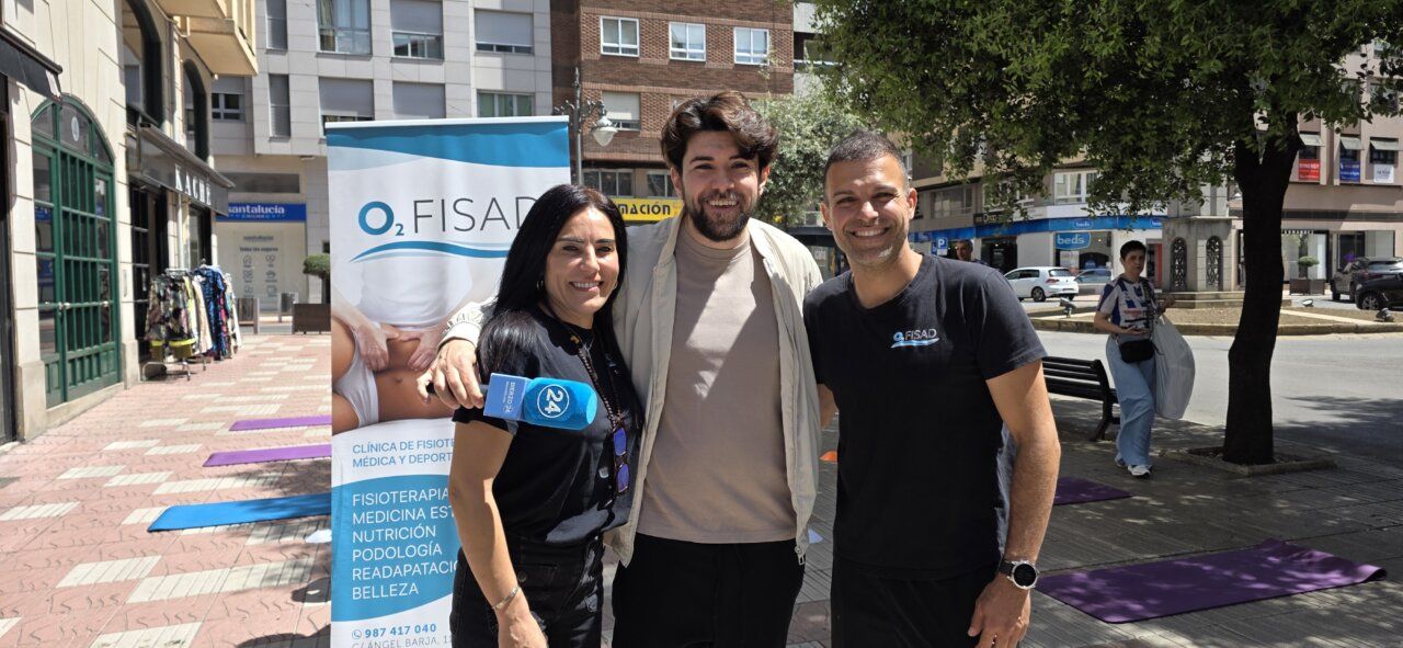 Tres personas sonrientes en un evento al aire libre en Ponferrada.