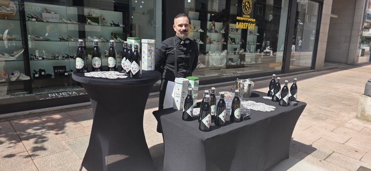 Un hombre sonriente en un evento al aire libre con bebidas y aperitivos.