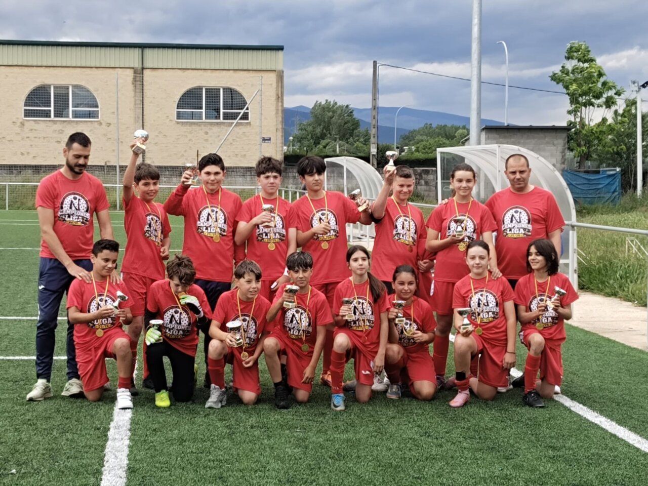 Equipo del C.D. Naraya celebrando un campeonato en el campo de fútbol