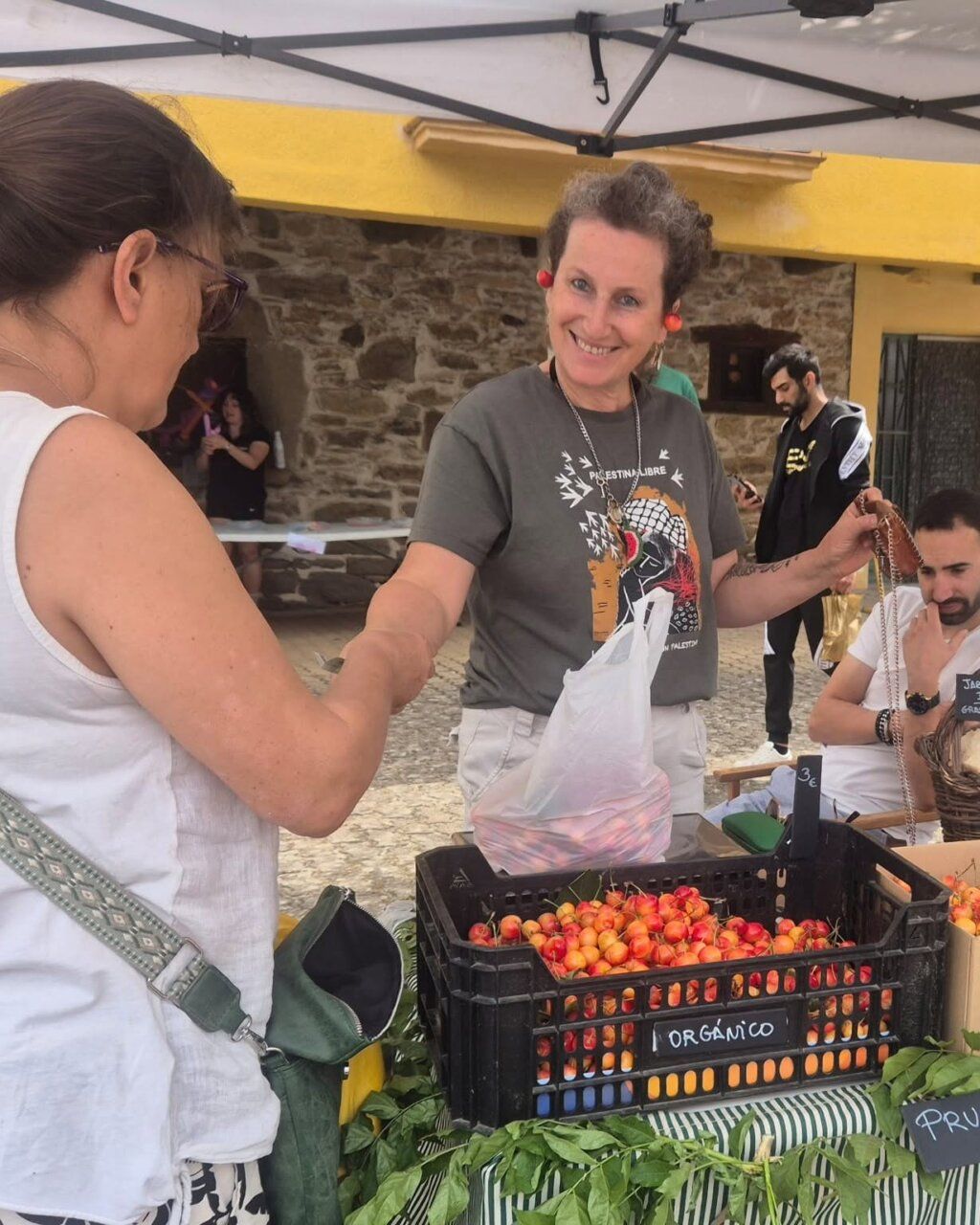 Mujer sonriente vendiendo productos agroalimentarios en feria de verano