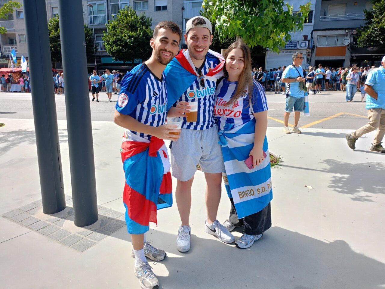 Tres aficionados de la SD Ponferradina en Vigo con camisetas y banderas