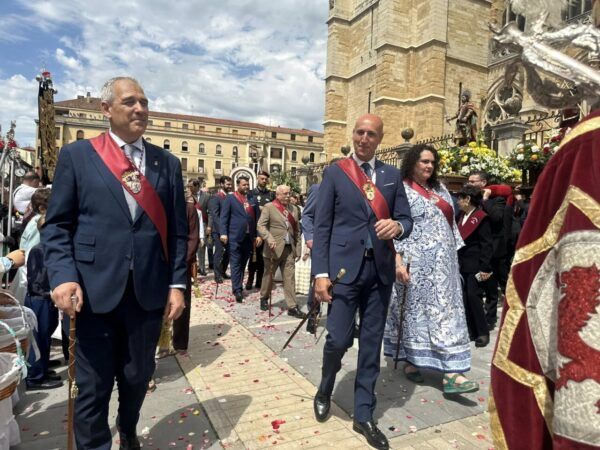 Procesión del Corpus Christi en el centro histórico de León con asistentes y decoraciones.