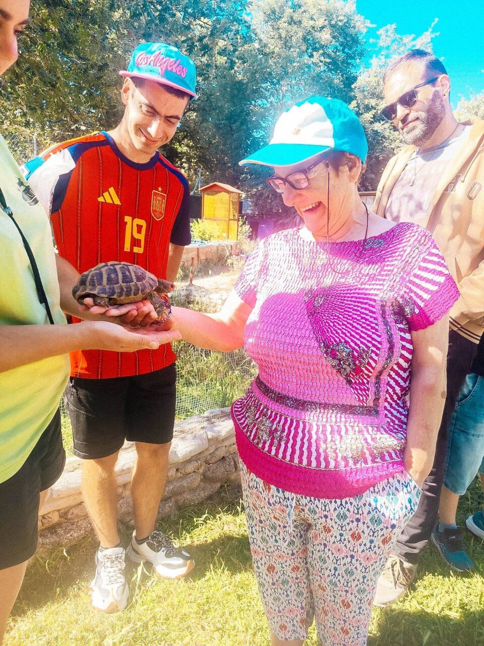 Grupo de personas disfrutando en la Finca Fiyuelo con una tortuga