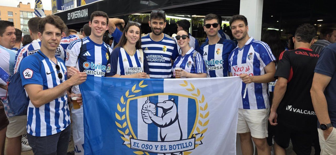 Aficionados de la Ponferradina sosteniendo una bandera en un evento