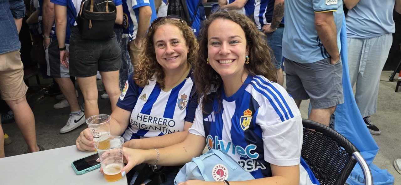 Dos mujeres sonriendo con camisetas de la Ponferradina en un evento deportivo