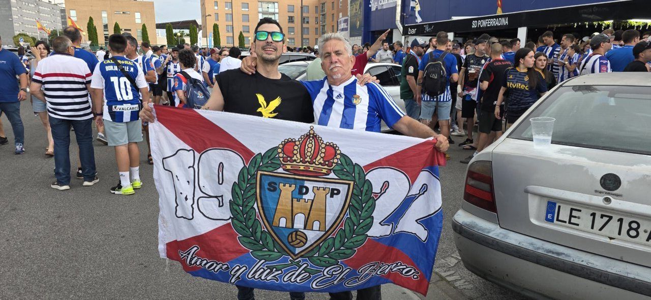 Aficionados de la Ponferradina sosteniendo una bandera en un partido