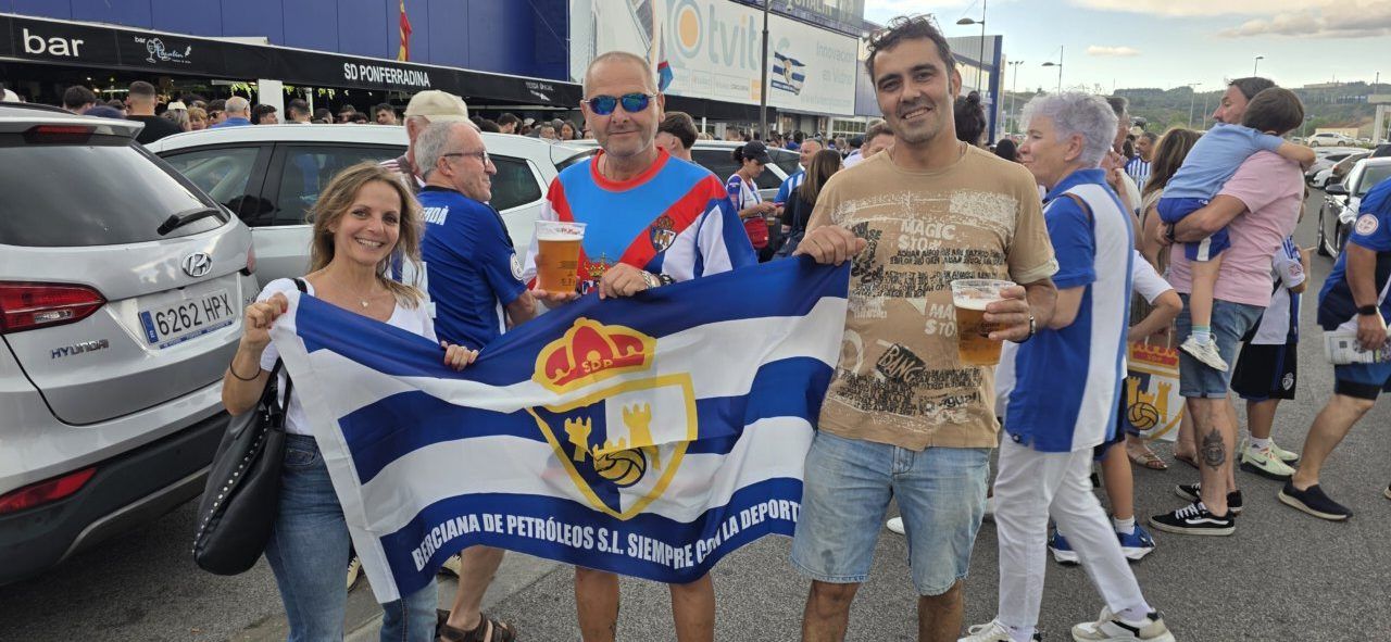 Aficionados de la Ponferradina sosteniendo una bandera en un evento