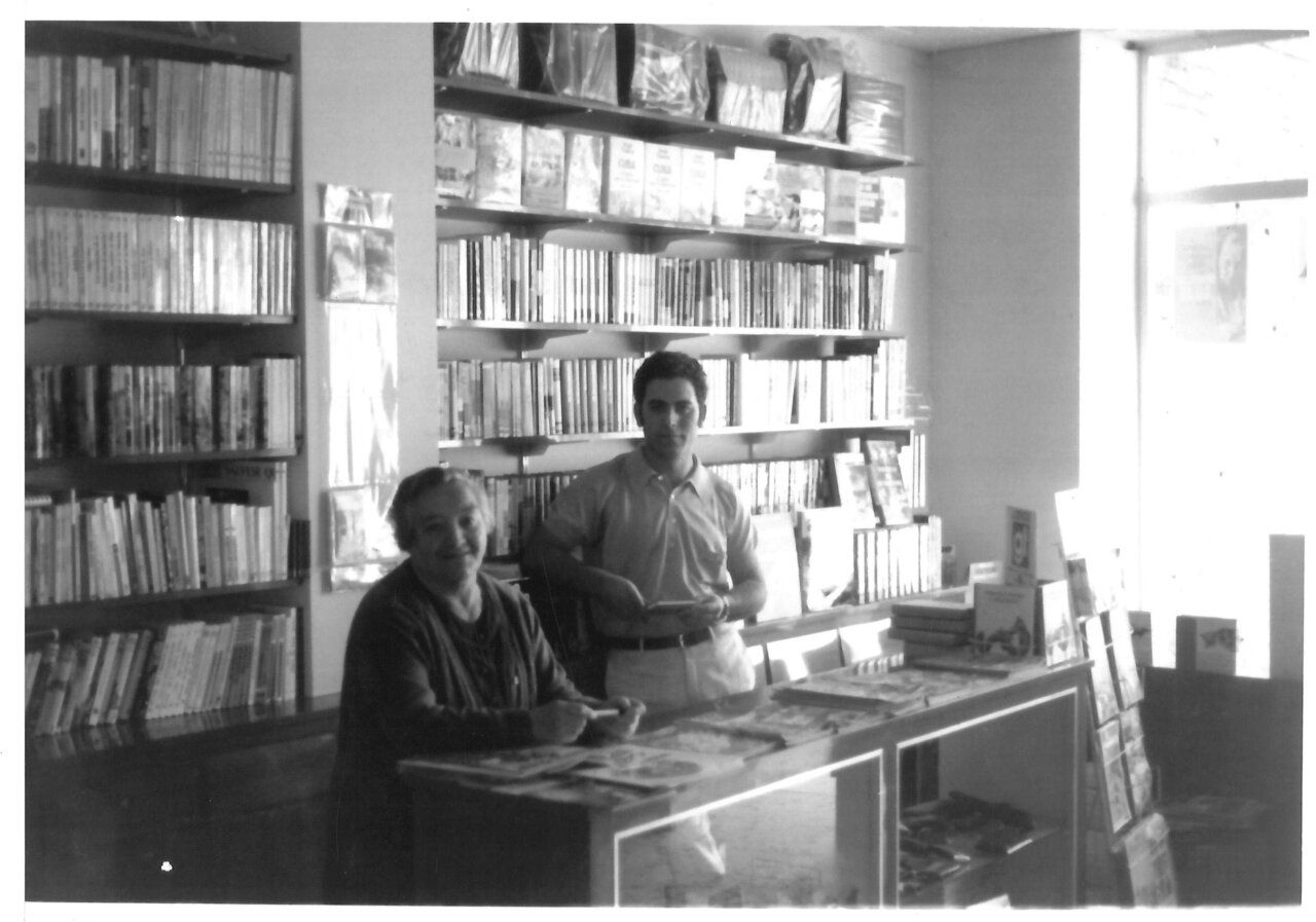 Interior de la librería Quiñones con dos personas y estantes llenos de libros
