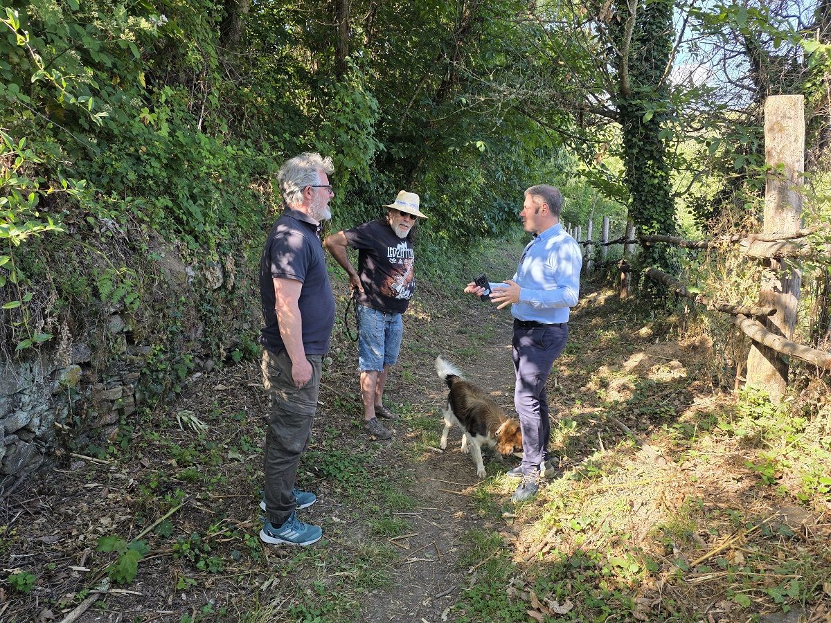 Tres hombres conversando en un sendero del Soto de Villar