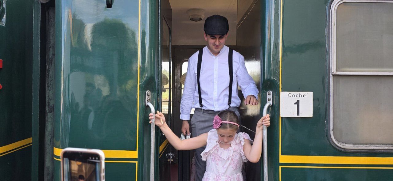 Niño y adulto bajando de un tren en Toral de los Vados