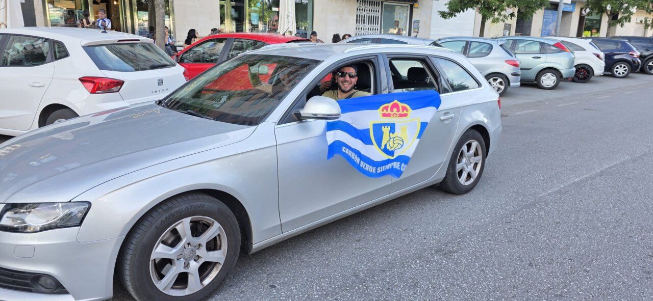 Aficionados de la SD Ponferradina animando desde un coche con bandera