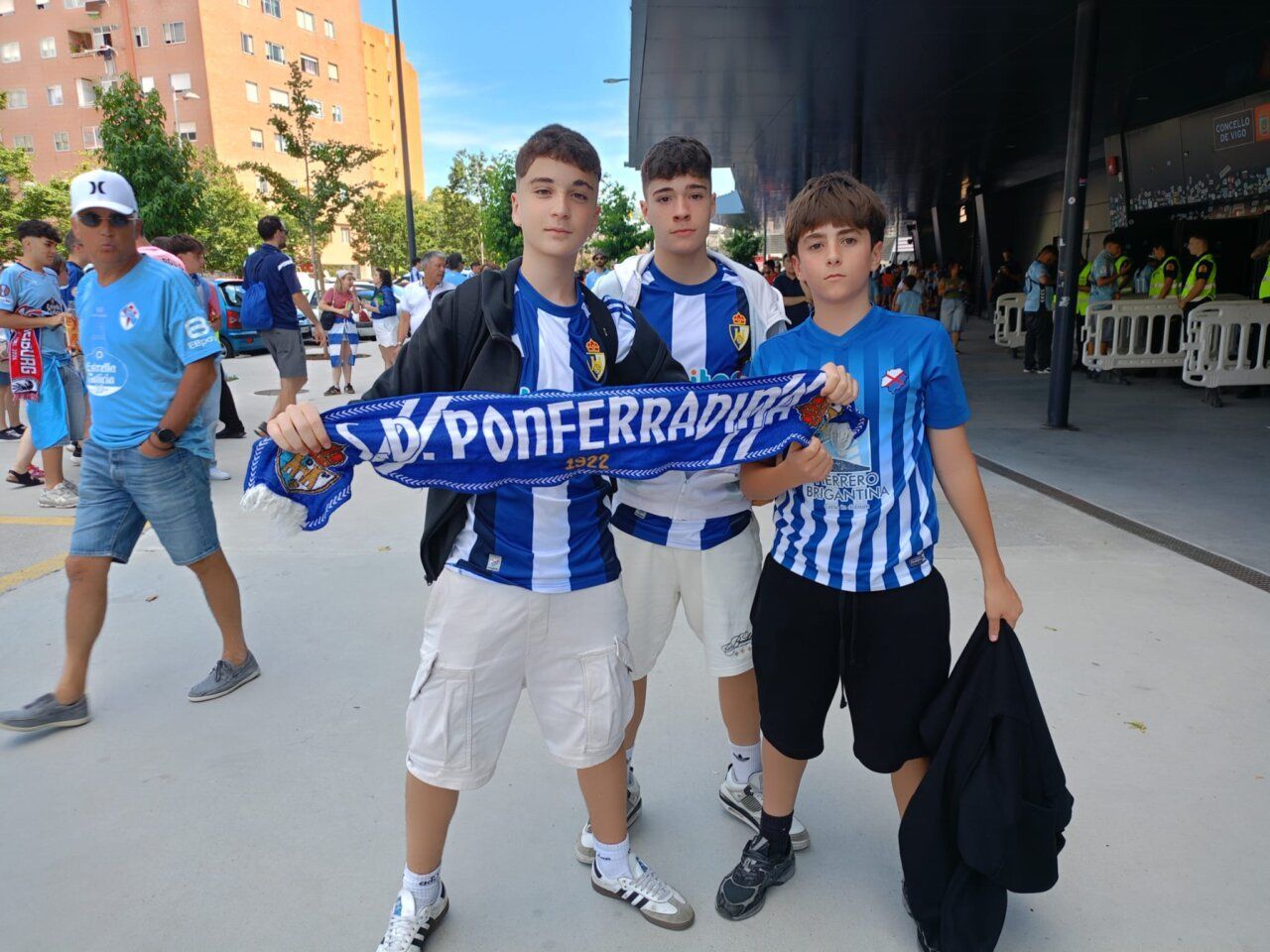Tres jóvenes aficionados de la SD Ponferradina con bufandas en Vigo.