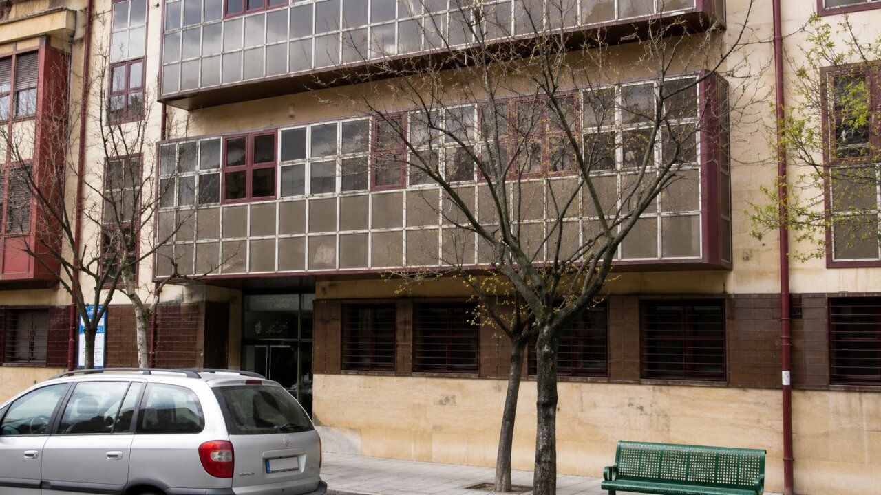 Fachada del ambulatorio San Antonio en Ponferrada con árboles y un coche estacionado.