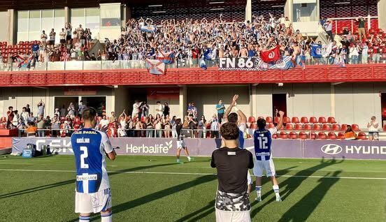 Jugadores celebrando con aficionados en el estadio durante el ascenso a Segunda División
