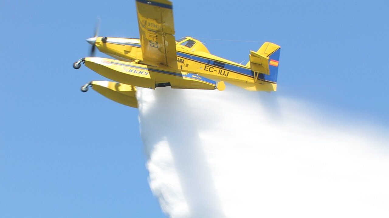 Avión amarillo realizando labores de extinción de incendios en el cielo