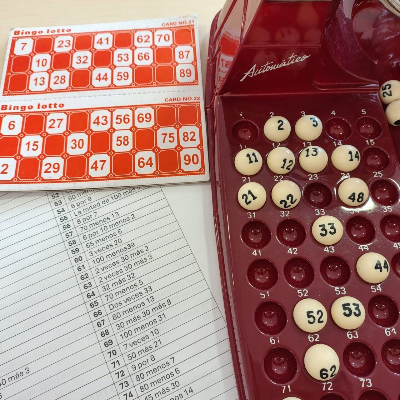 Cartones de bingo y bolitas numeradas en una sesión de bingo matemático