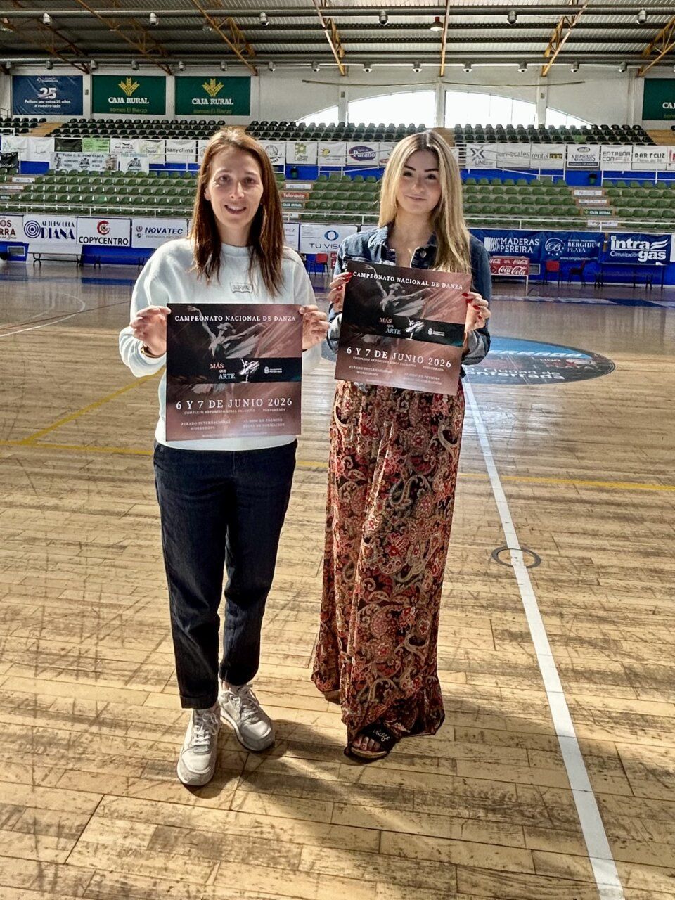 Dos mujeres sosteniendo carteles del Campeonato Nacional de Danza Más que Arte