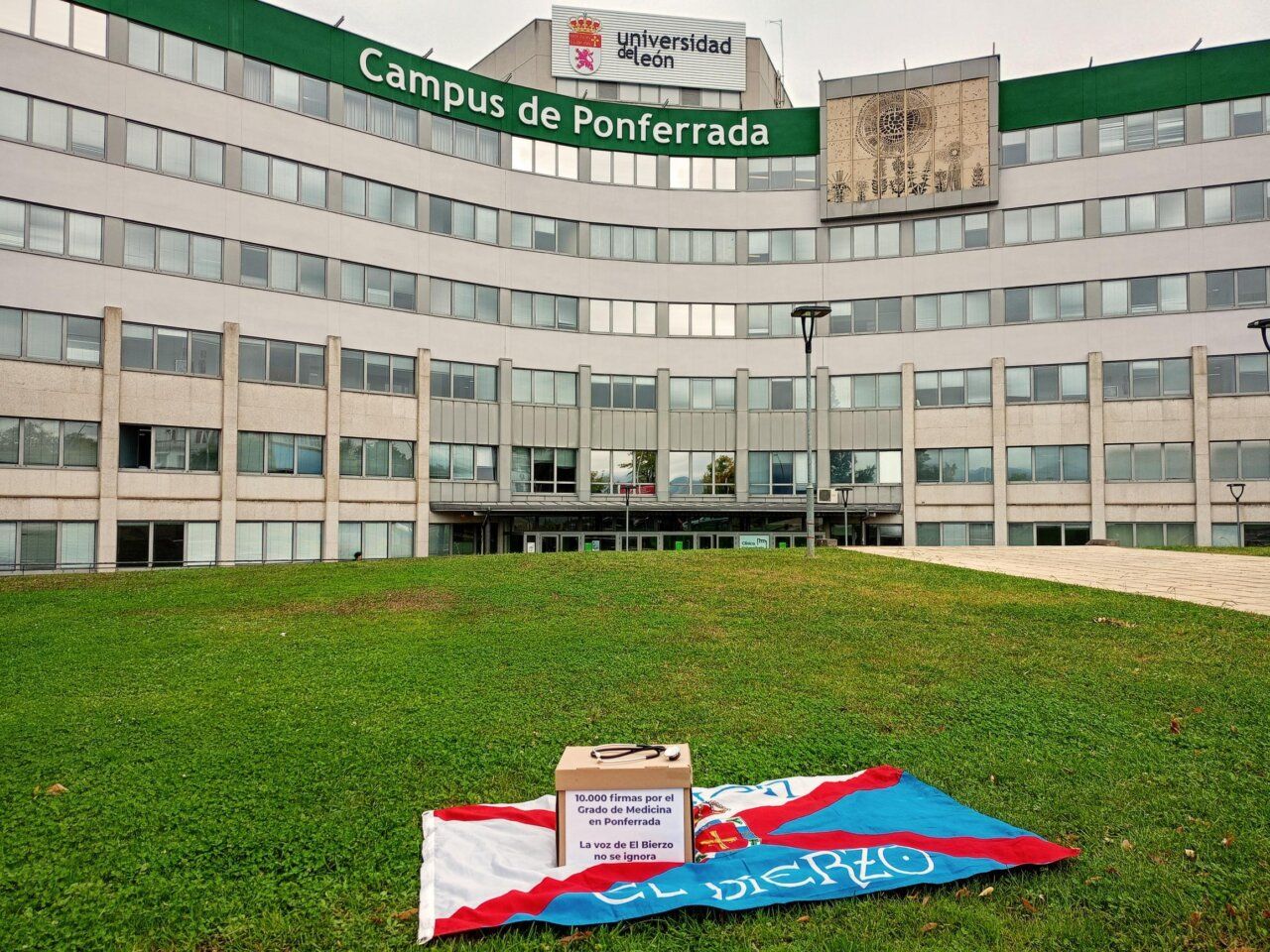 Exterior del Campus de Ponferrada con una bandera y una caja de firmas