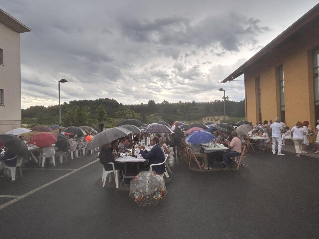 Cena de la asociación en Arganza bajo la lluvia con paraguas