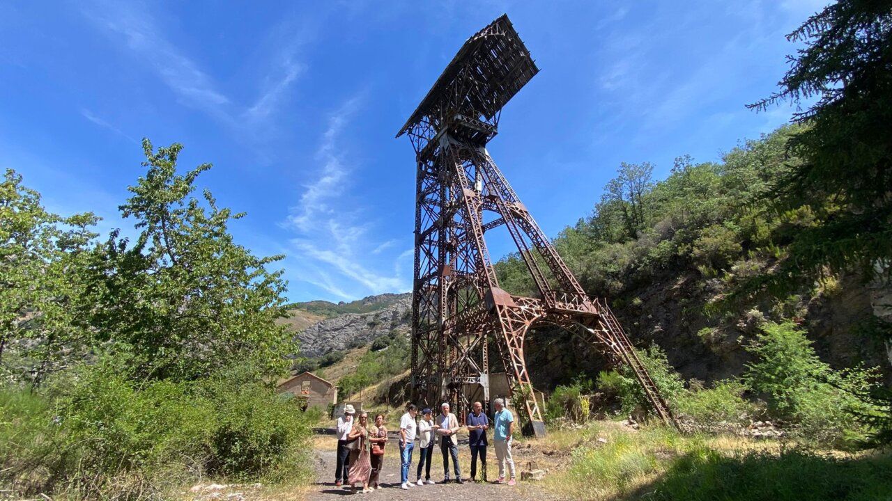 Grupo de personas junto a una estructura histórica en un entorno natural