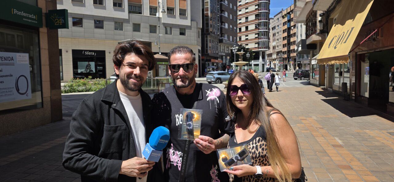 Tres personas sosteniendo gafas de eclipse en Ponferrada