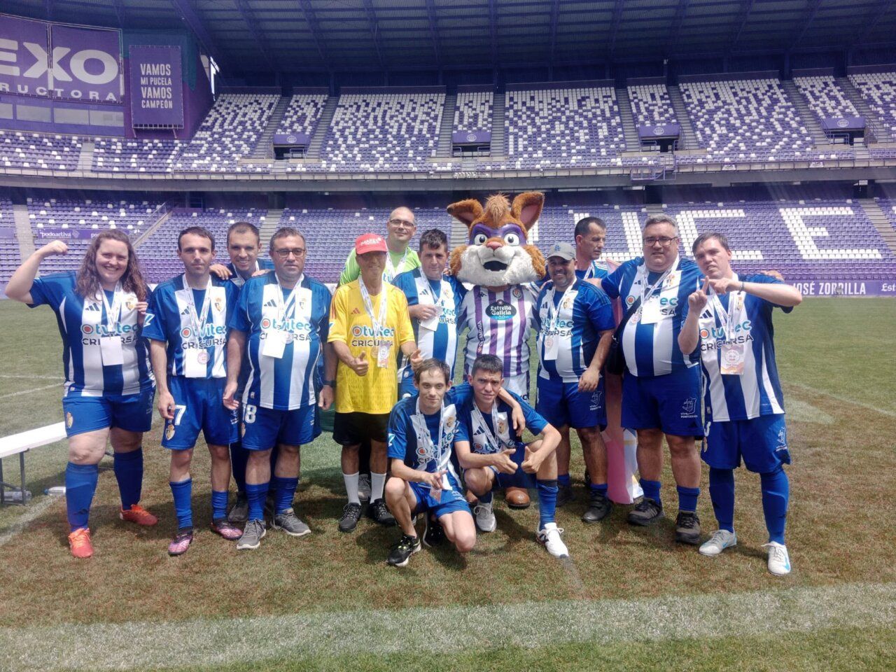 El equipo Genuine posando en el campo con medallas y un mascota