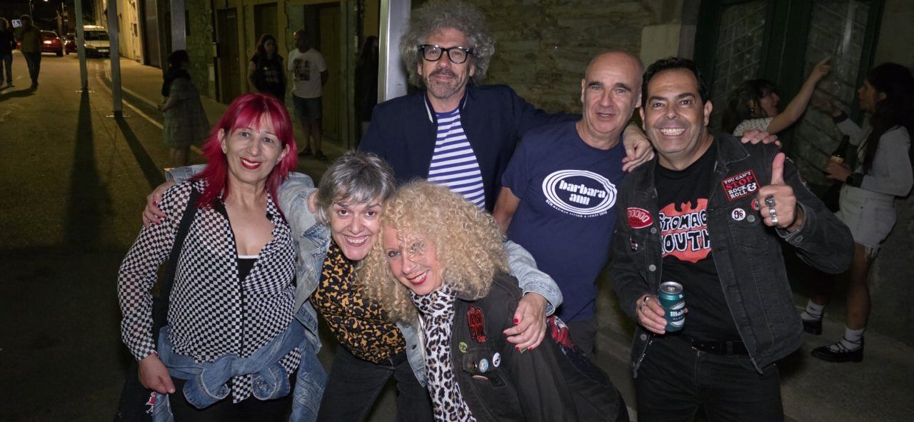 Grupo de personas posando en un evento festivo por la noche.