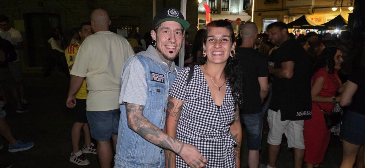 Pareja sonriente en un festival al aire libre con mucha gente