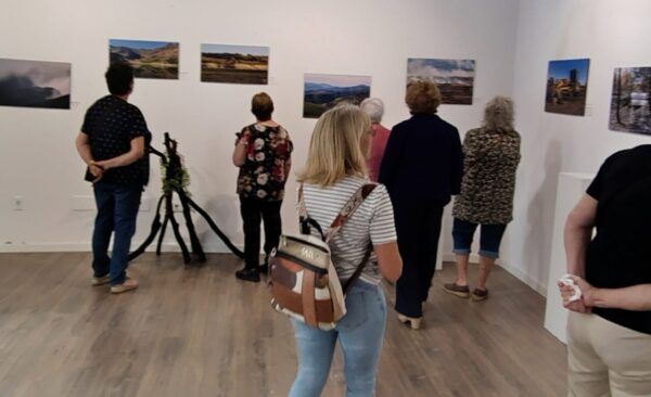 Visitantes observando fotografías en la exposición Ahora… Cenizas