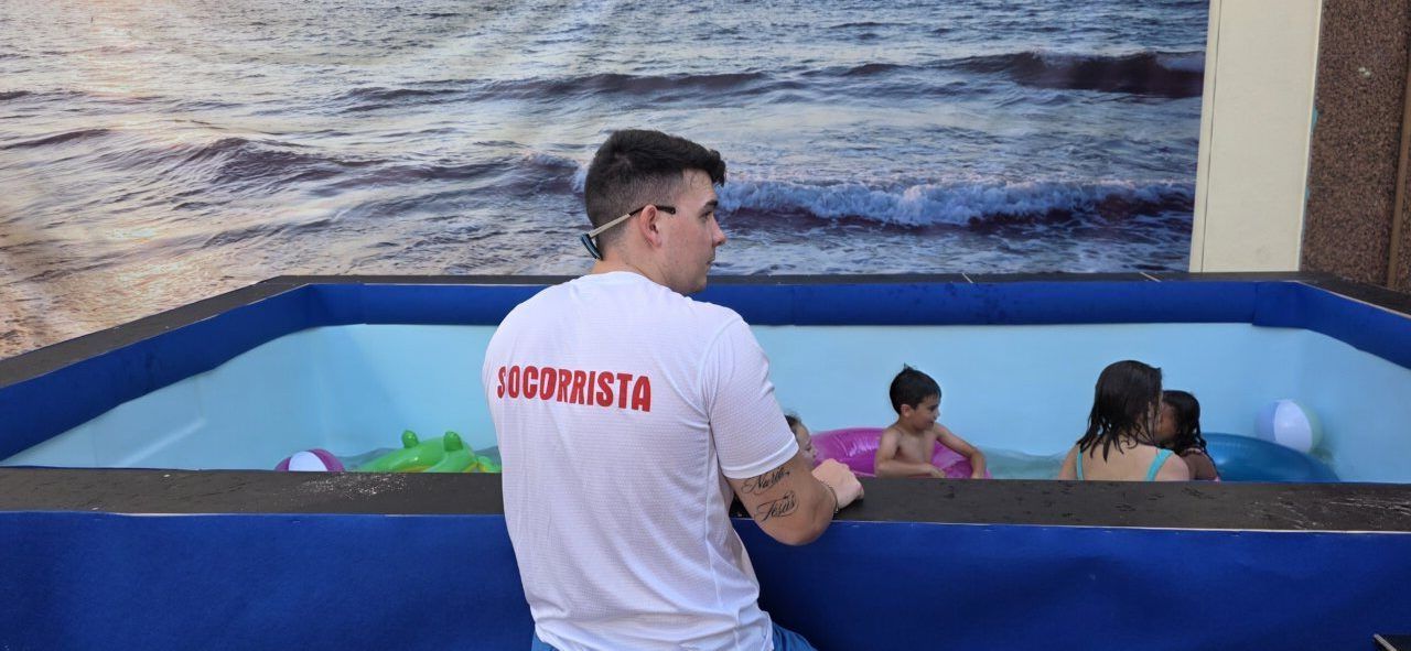 Socorrista supervisando a niños en una piscina inflable durante el evento Flower Power.