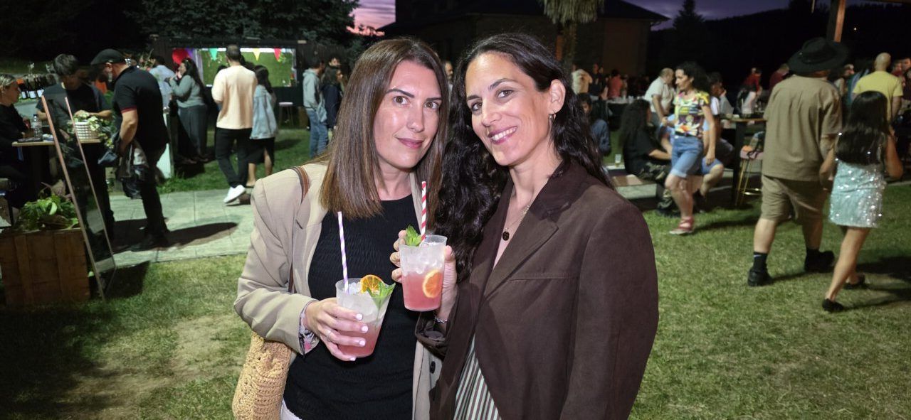Dos mujeres sosteniendo cócteles en la inauguración de la terraza de verano.