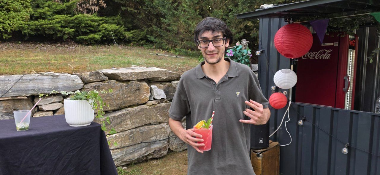 Joven sosteniendo un cóctel en la terraza de verano del Mesón Real.