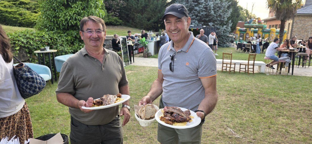 Dos hombres sosteniendo platos con comida en la inauguración de la terraza de verano.