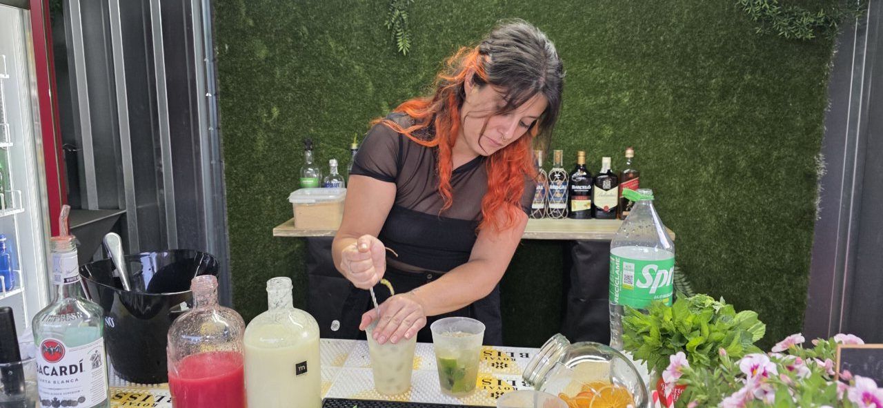 Mujer preparando cócteles en la terraza de verano del Mesón Real
