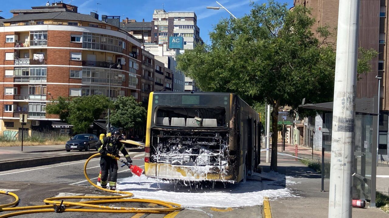 Autobús urbano en Ponferrada con motor incendiado y bomberos apagando el fuego.