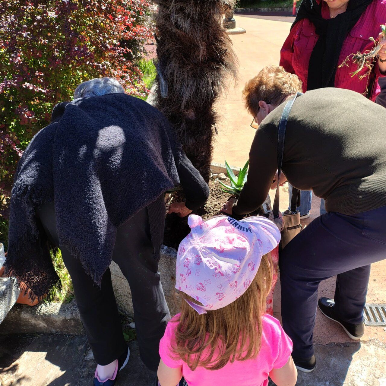 Niños y mayores plantando en un jardín intergeneracional en El Bierzo
