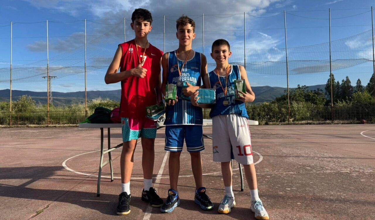 Tres jóvenes jugadores de baloncesto posando con medallas y trofeos