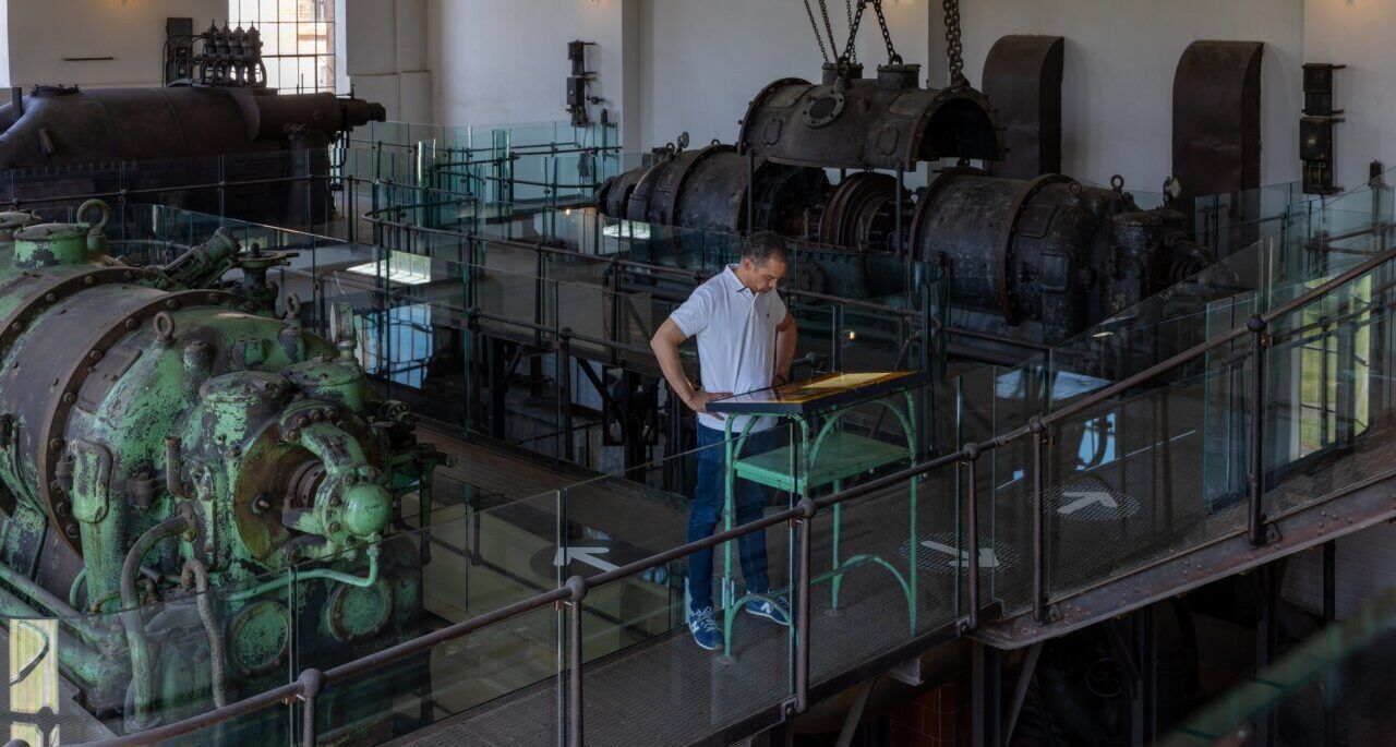 Interior de La Fábrica de Luz con maquinaria industrial y un visitante
