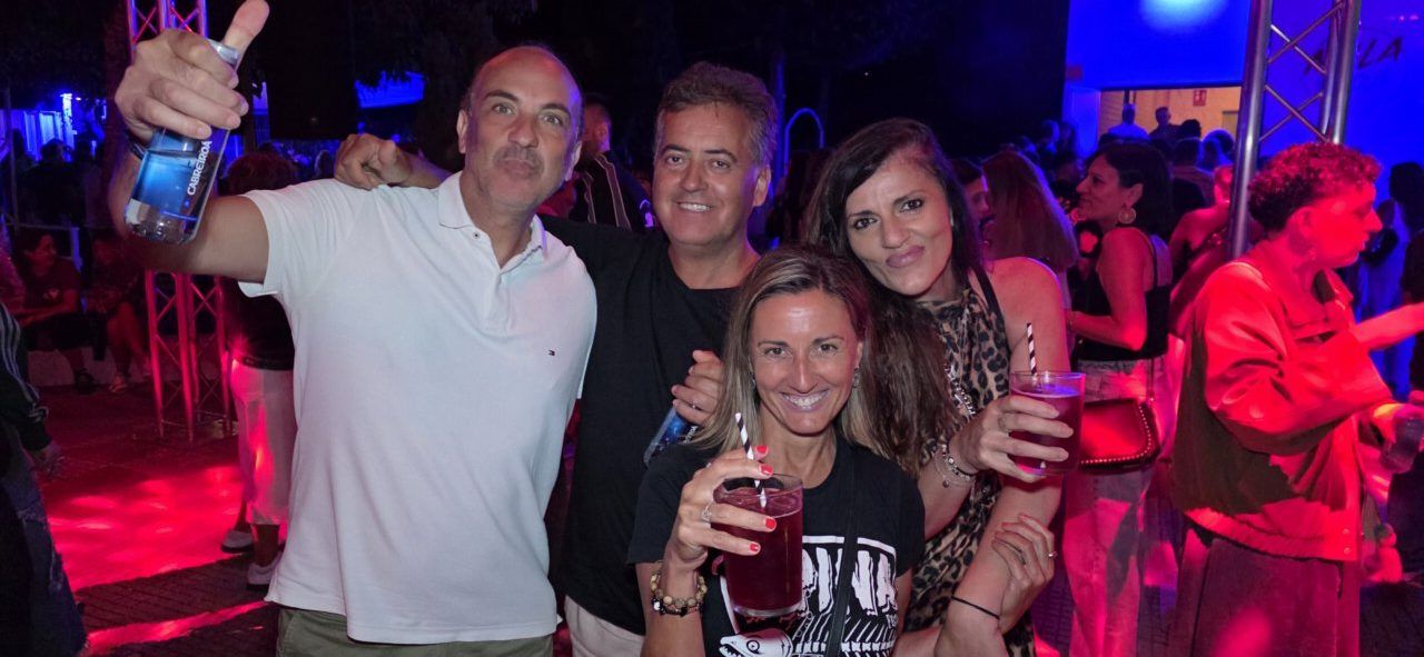 Grupo de amigos disfrutando en una fiesta con bebidas en las manos