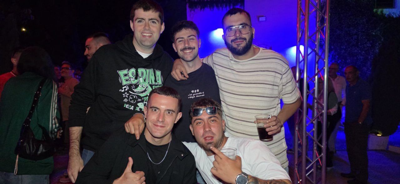 Grupo de amigos posando en una fiesta con luces de fondo