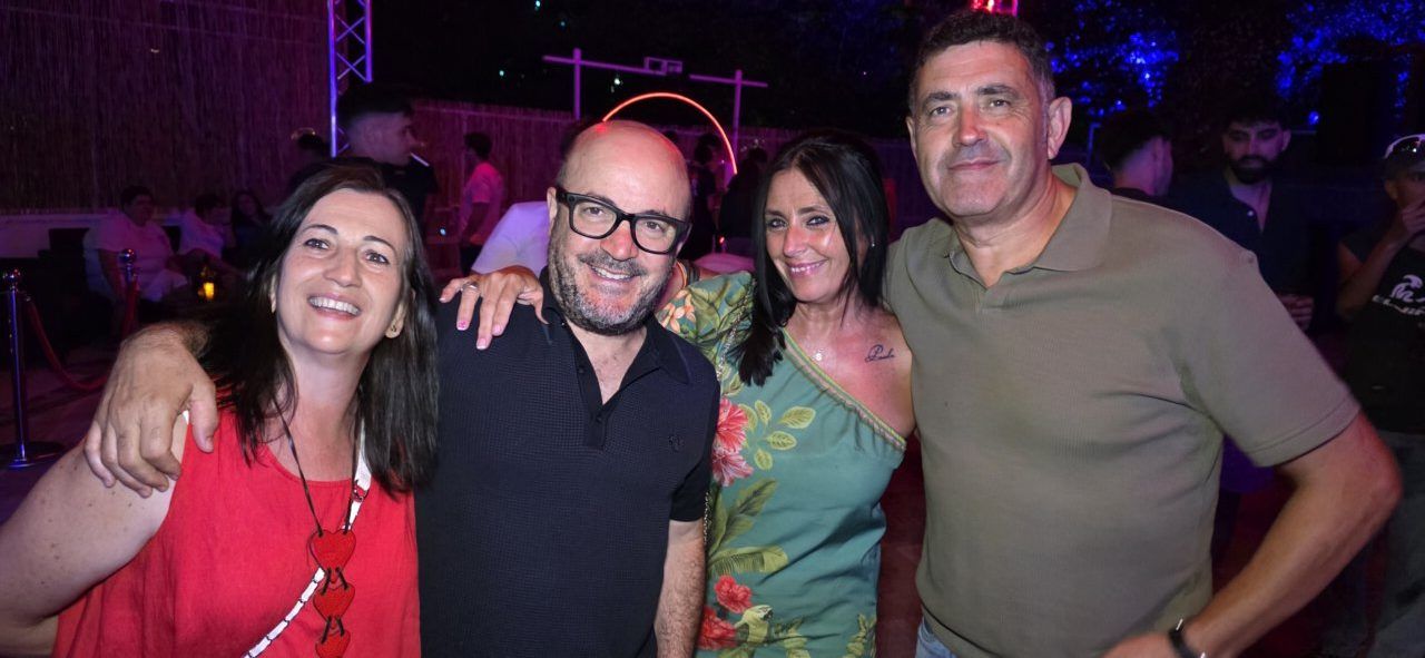 Grupo de amigos sonriendo en una fiesta nocturna