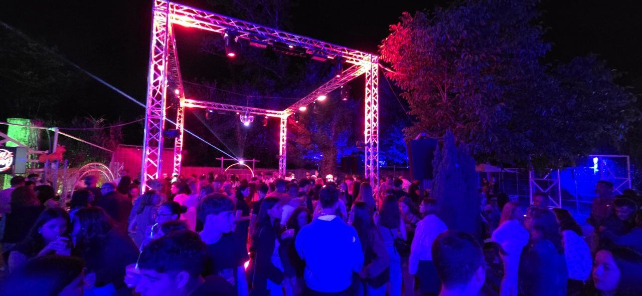 Multitud disfrutando de una fiesta nocturna con luces brillantes