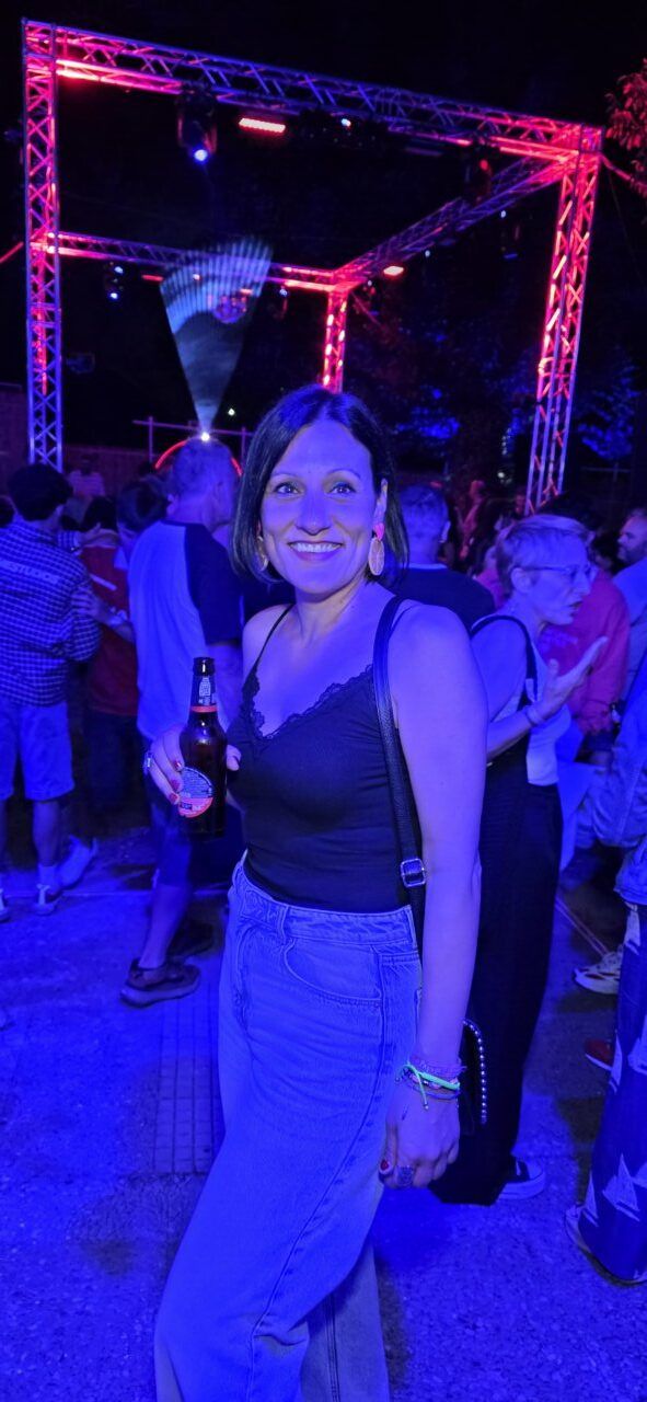 Mujer sonriendo en una fiesta nocturna con luces de colores